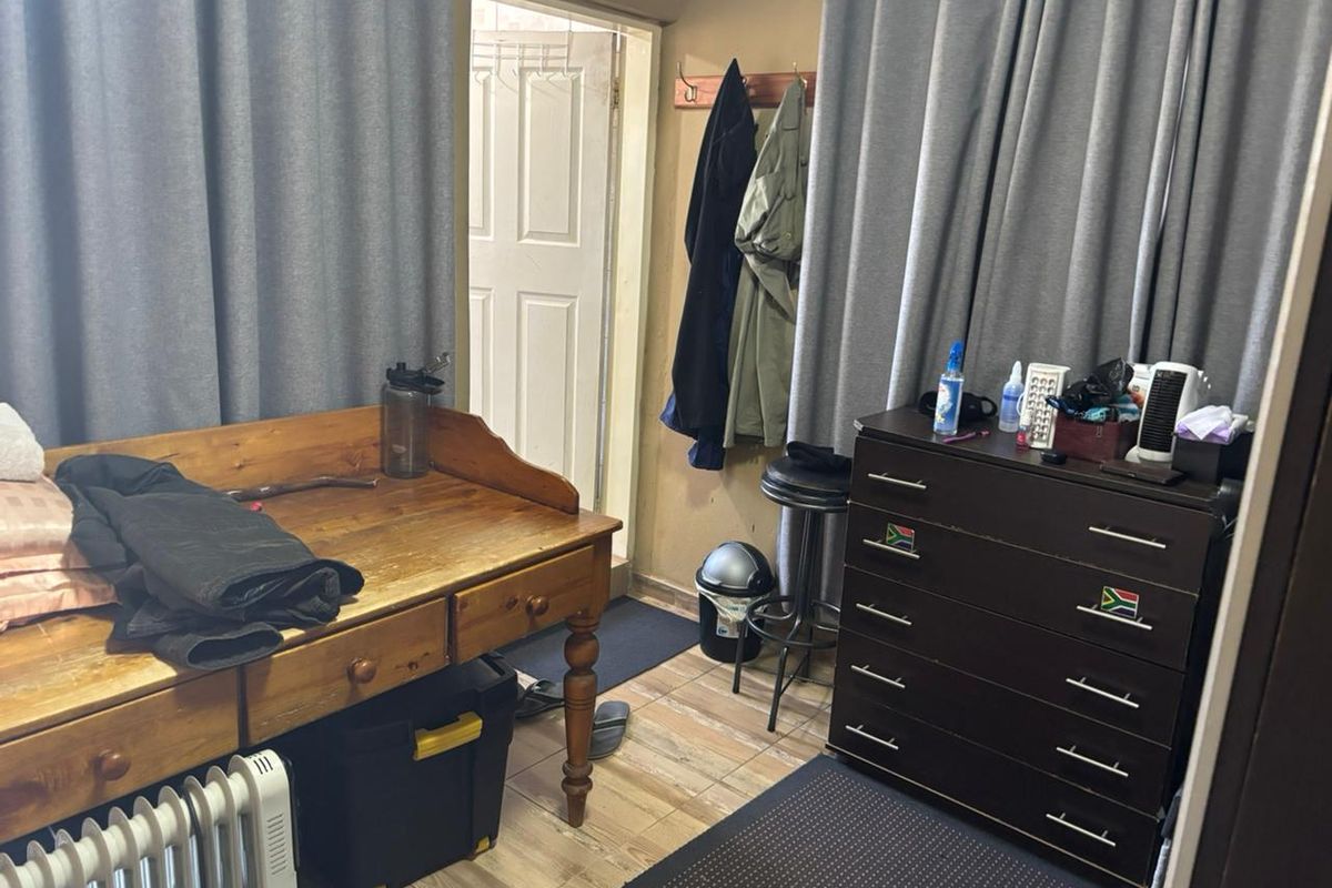 A functional bedroom space featuring tiled flooring and a standard entry door, providing a practical layout for personal use.