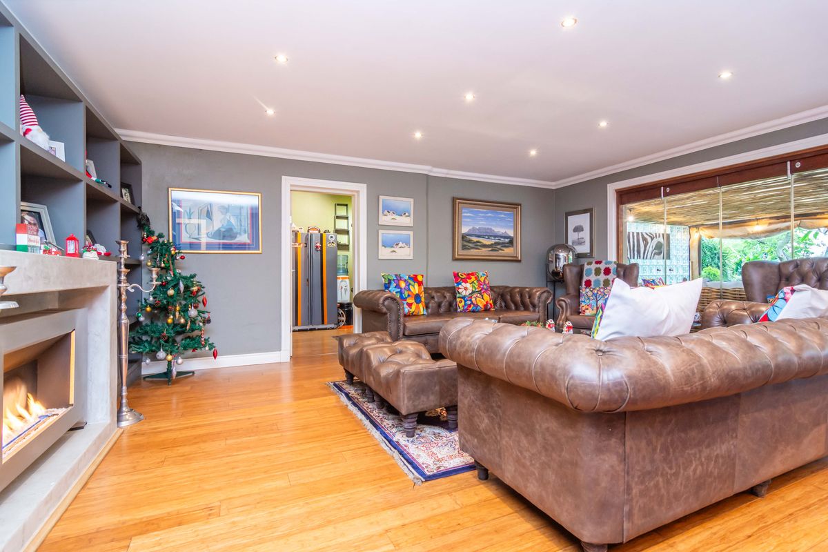 Spacious living room featuring hardwood flooring, a modern recessed fireplace, built-in shelving, and large sliding glass doors leading to an outdoor area.
