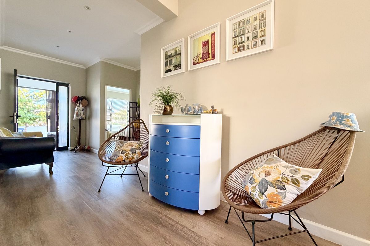 A bright and open living area featuring modern laminate flooring, recessed lighting, and a sliding glass door leading to an outdoor space.