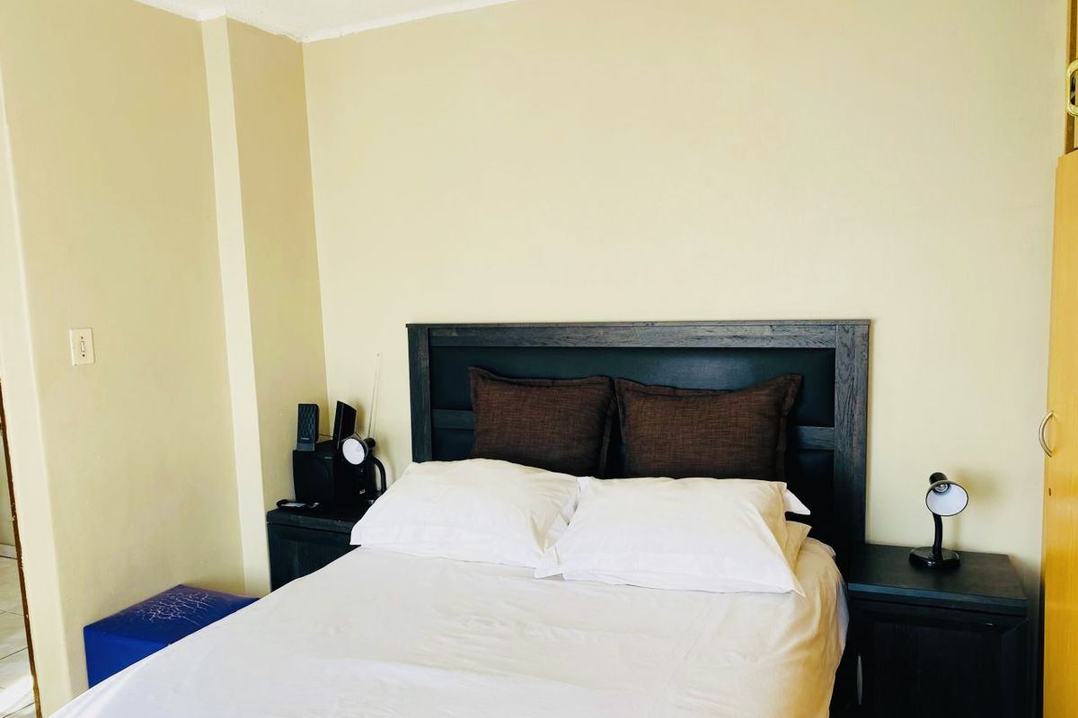 A standard bedroom featuring neutral wall finishes and a built-in wardrobe, providing a functional and simple living space.