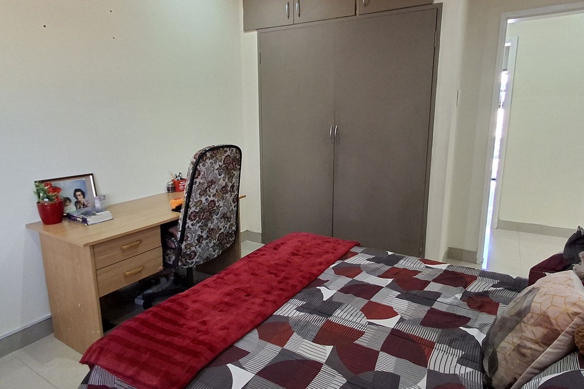 Bedroom featuring built-in wardrobes with overhead storage, tiled flooring, and a timber tongue and groove ceiling.
