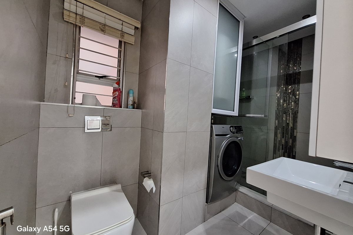 Modern bathroom featuring a wall-hung toilet with concealed cistern, glass-enclosed shower with mosaic accents, and a wall-mounted basin with integrated cabinetry.