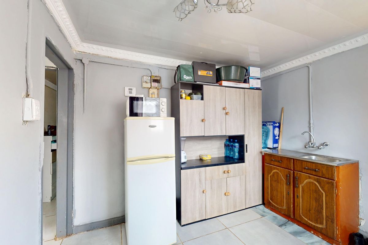 A functional kitchen area featuring basic cabinetry, a stainless steel sink, and surface-mounted electrical infrastructure.