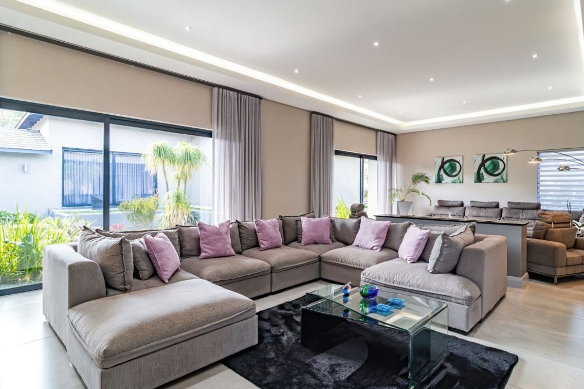Spacious, modern living room featuring large sliding glass doors, recessed ceiling lighting, and high-quality tiled flooring, creating a bright and open atmosphere.