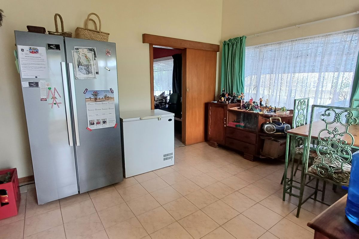 A functional kitchen area featuring tiled flooring and a sliding wooden door, providing access to adjacent living spaces.