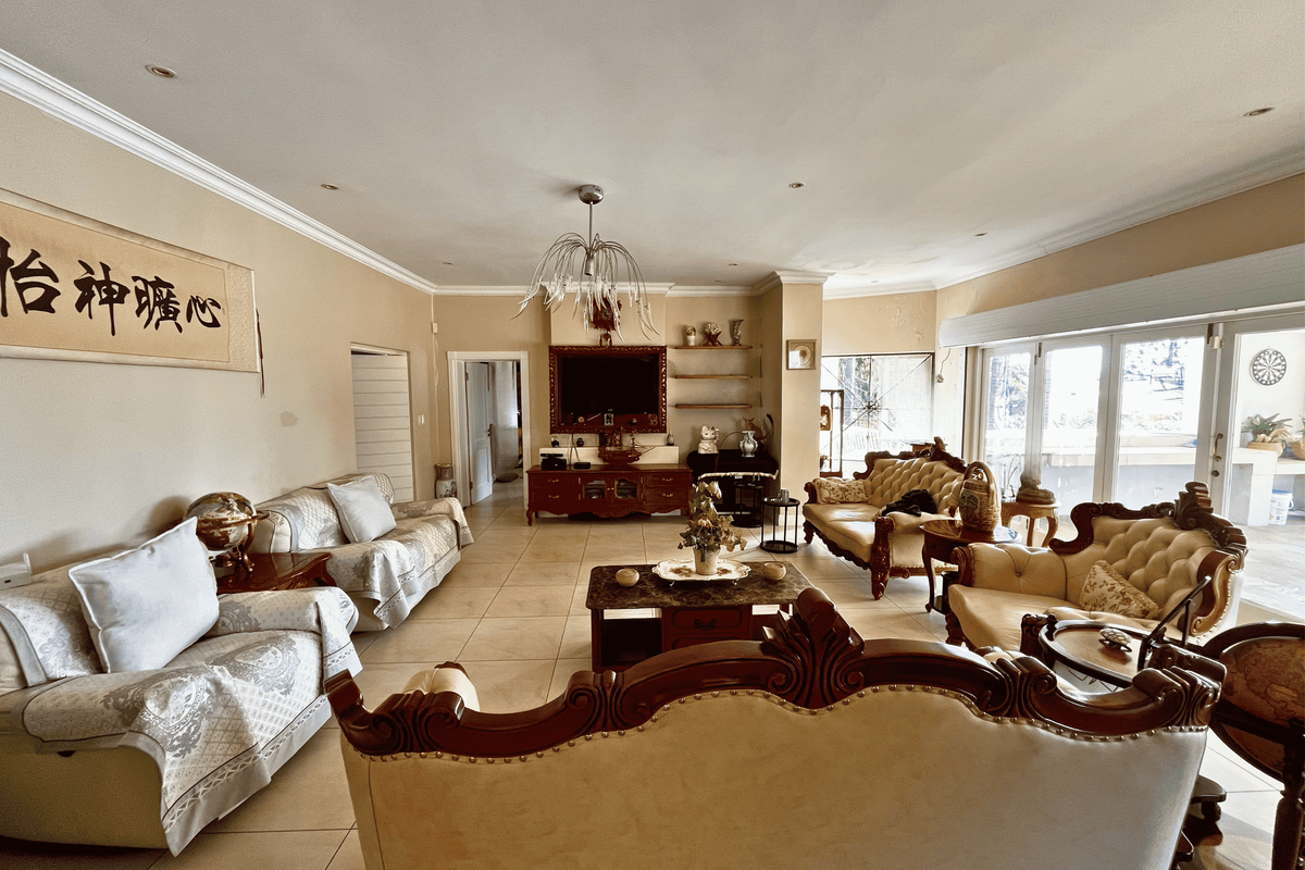 Spacious living room featuring tiled flooring, recessed lighting, and large sliding glass doors that provide ample natural light and access to the patio.