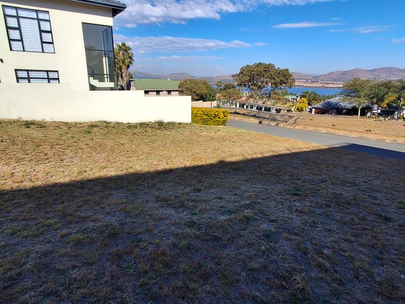 Elevated view overlooking the residential estate, surrounding landscape, and distant water, showcasing the property's scenic outlook and position.