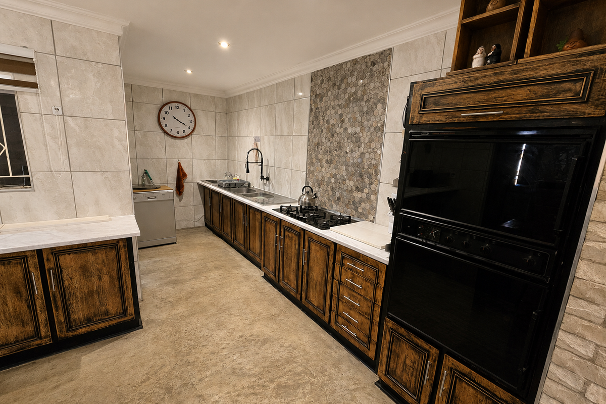A well-maintained kitchen featuring rustic-style cabinetry, a gas hob, built-in oven, double sink, and modern tiled splashback with recessed lighting.