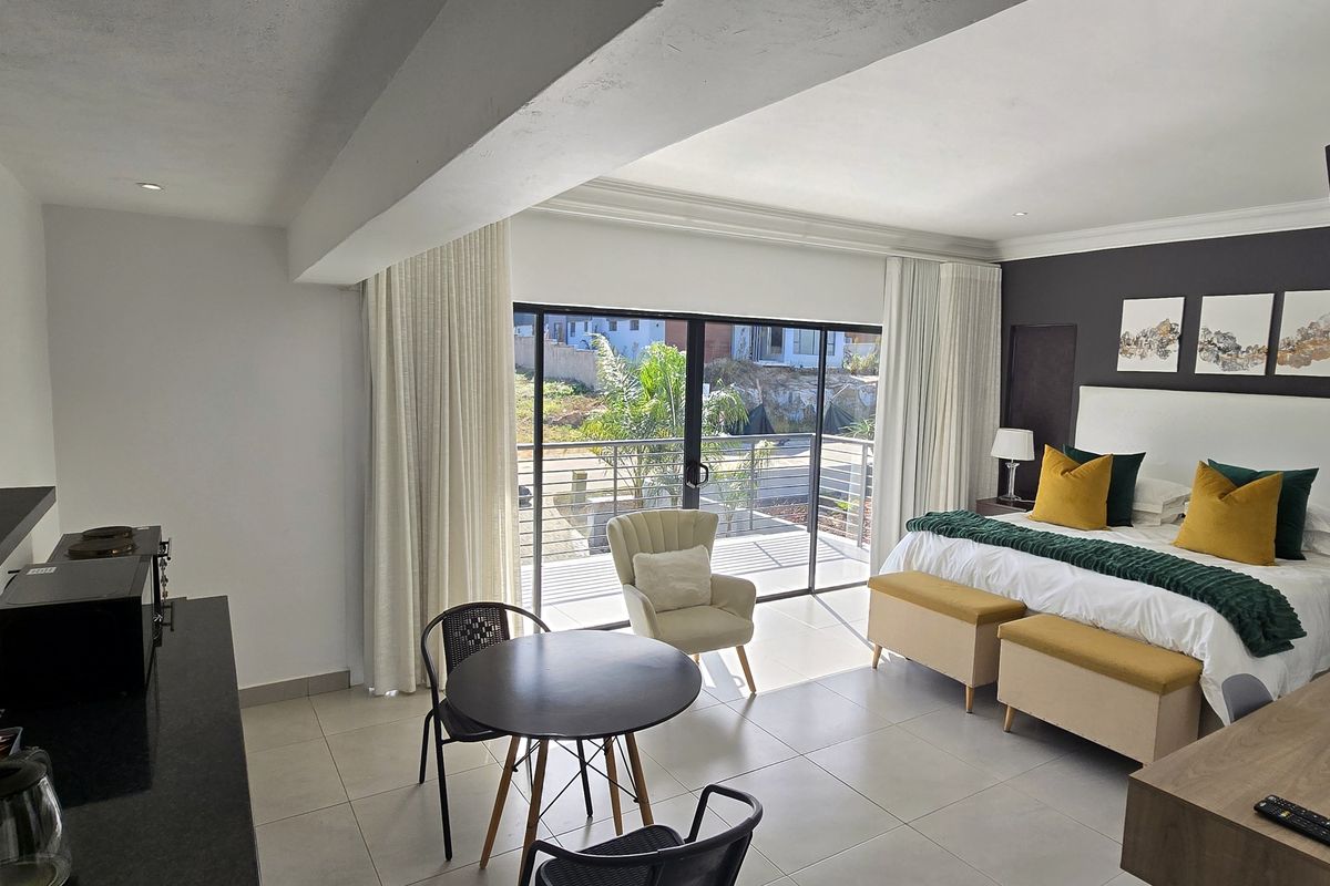 Spacious bedroom featuring tiled flooring, recessed lighting, and a large sliding glass door providing direct access to a private balcony.