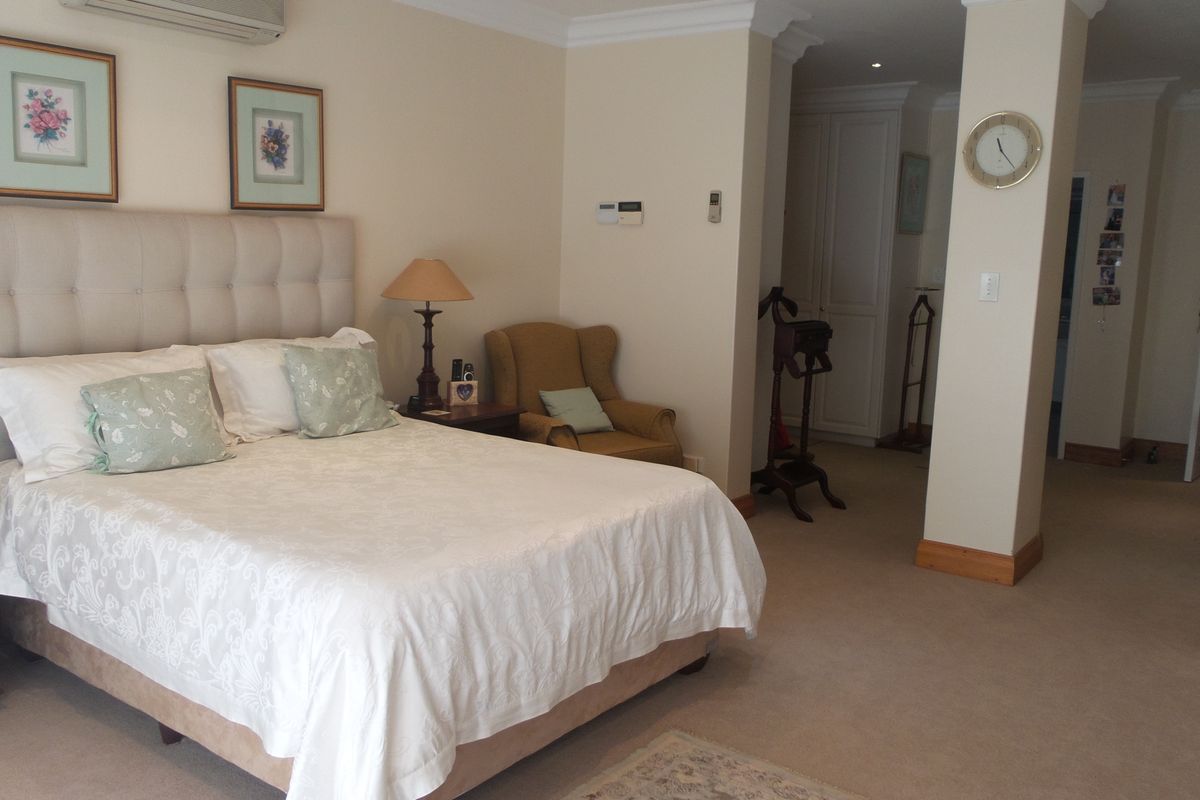 Spacious bedroom featuring neutral carpeting, built-in storage, recessed lighting, and an integrated air conditioning unit.