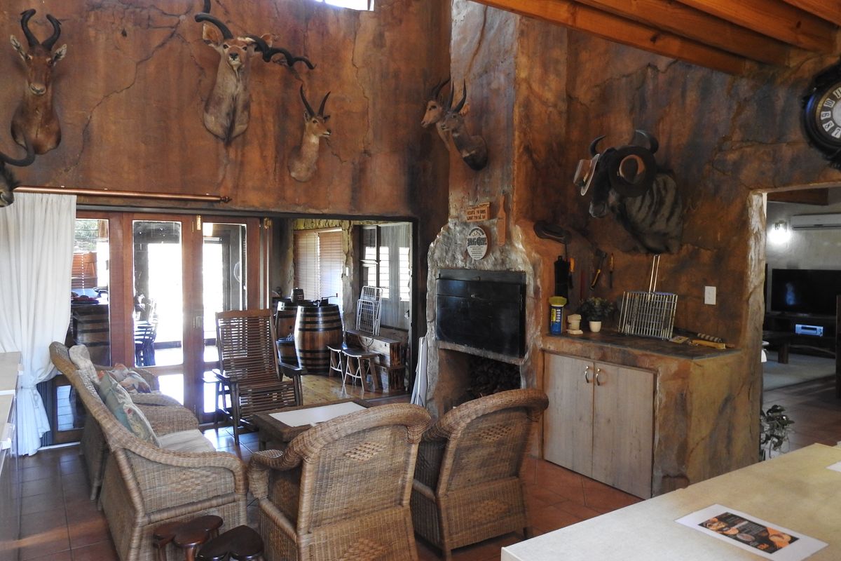 Spacious living area featuring a large built-in fireplace, textured feature walls, and direct access to an outdoor patio area.