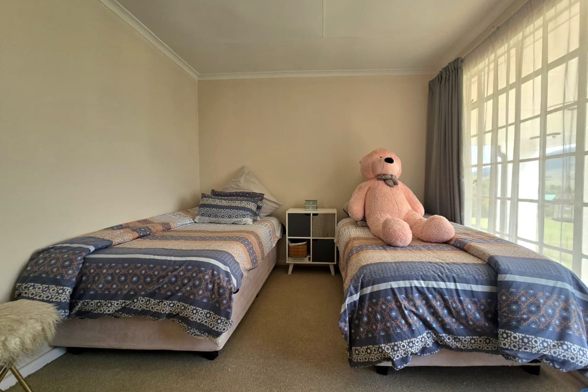 A functional bedroom featuring carpeted flooring, a large window with natural light, and coved ceiling finishes.