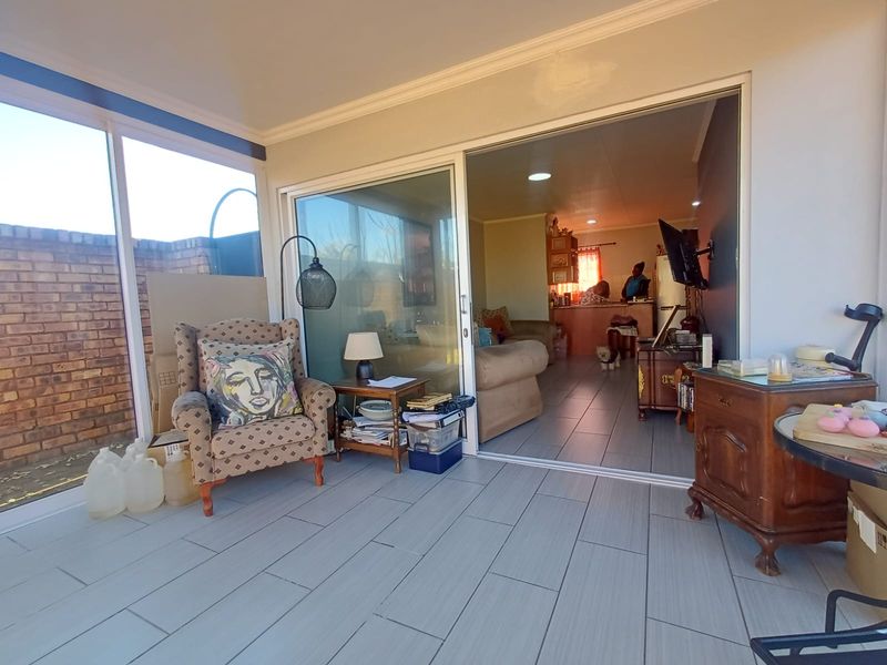 Enclosed patio area featuring tiled flooring and large sliding glass doors, providing a seamless transition to the interior living space.