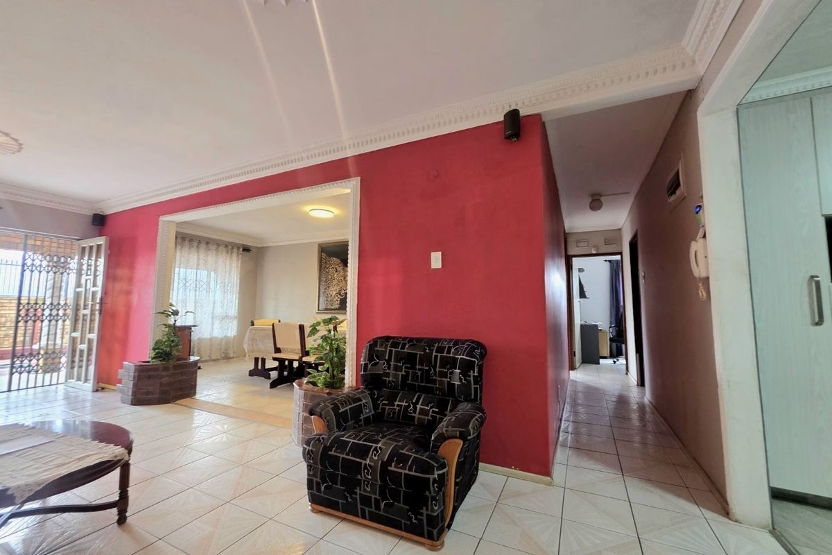 Spacious living area featuring ceramic floor tiles, decorative ceiling cornices, and an open-plan layout connecting to the dining space.