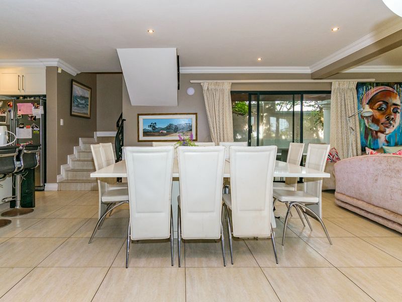 Open plan living and dining area featuring tiled flooring, recessed ceiling lighting, and direct access to the outdoor patio through sliding glass doors.