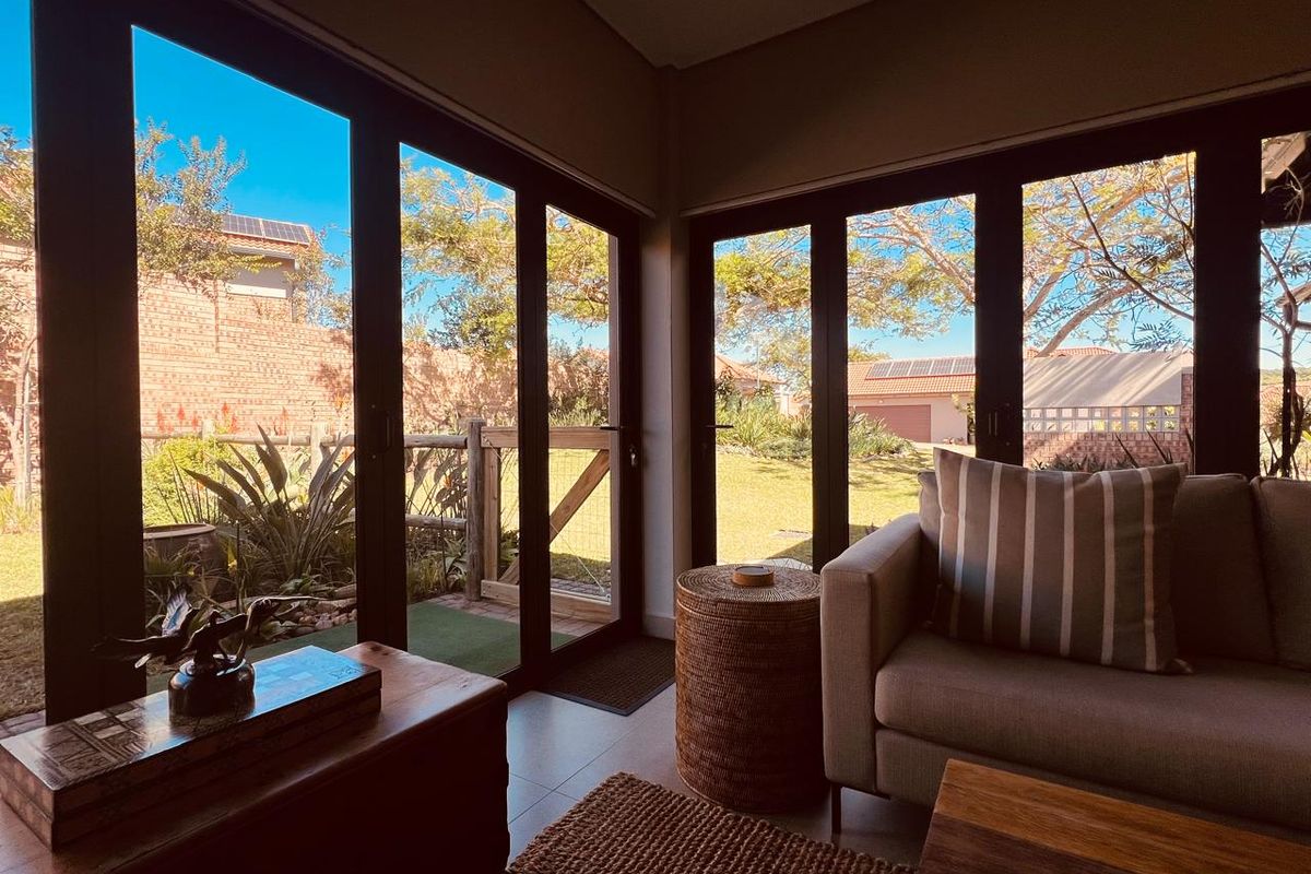 A bright living area featuring large glass sliding doors that provide seamless access to the garden and ample natural light.