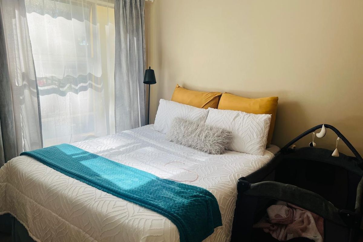A bedroom featuring natural light from a window with installed curtain tracks.