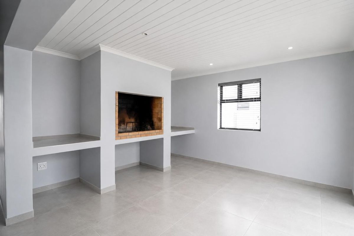 A bright, empty living area featuring a built-in brick fireplace, concrete shelving, modern tiled flooring, and a clean tongue and groove ceiling.