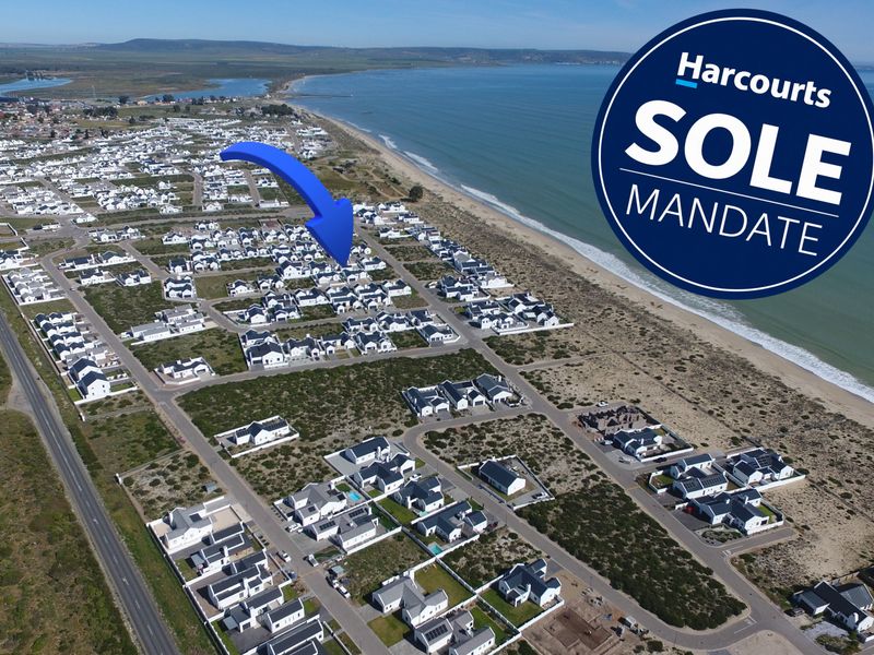 Aerial view of a coastal residential estate, highlighting the property's proximity to the beach and surrounding neighbourhood layout.