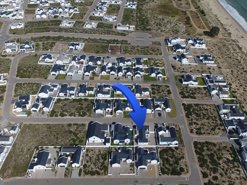Aerial view of a coastal residential estate showing the property location, surrounding housing, and proximity to the beach.