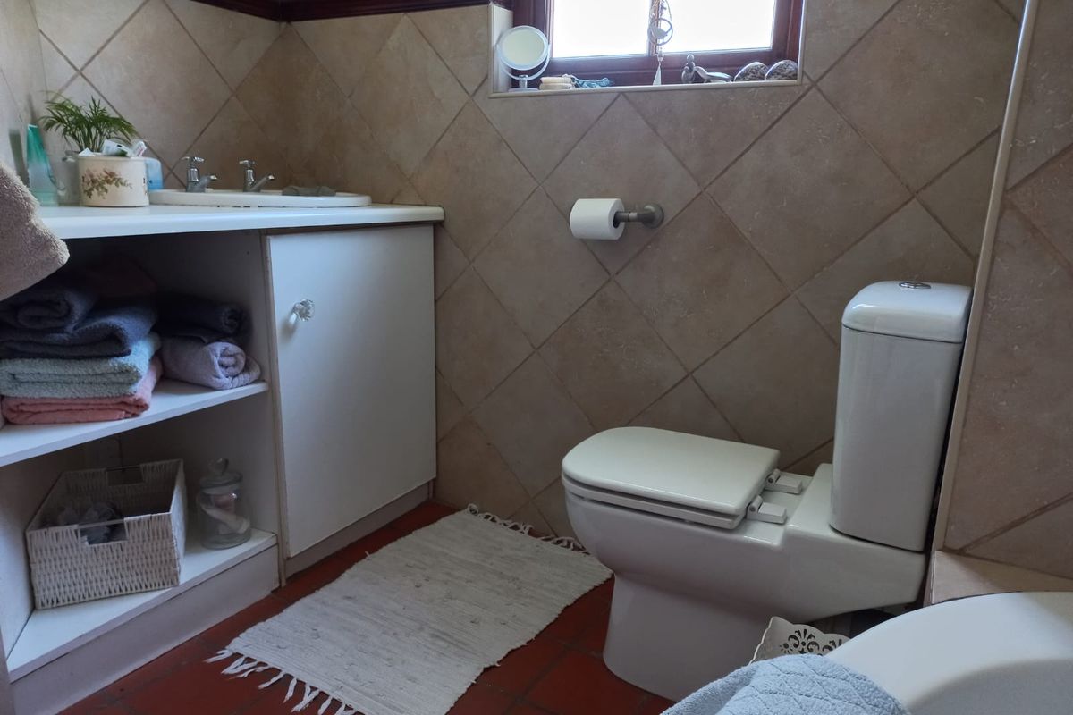 A functional bathroom featuring a vanity cabinet with a basin, a standard toilet, and tiled wall and floor finishes.