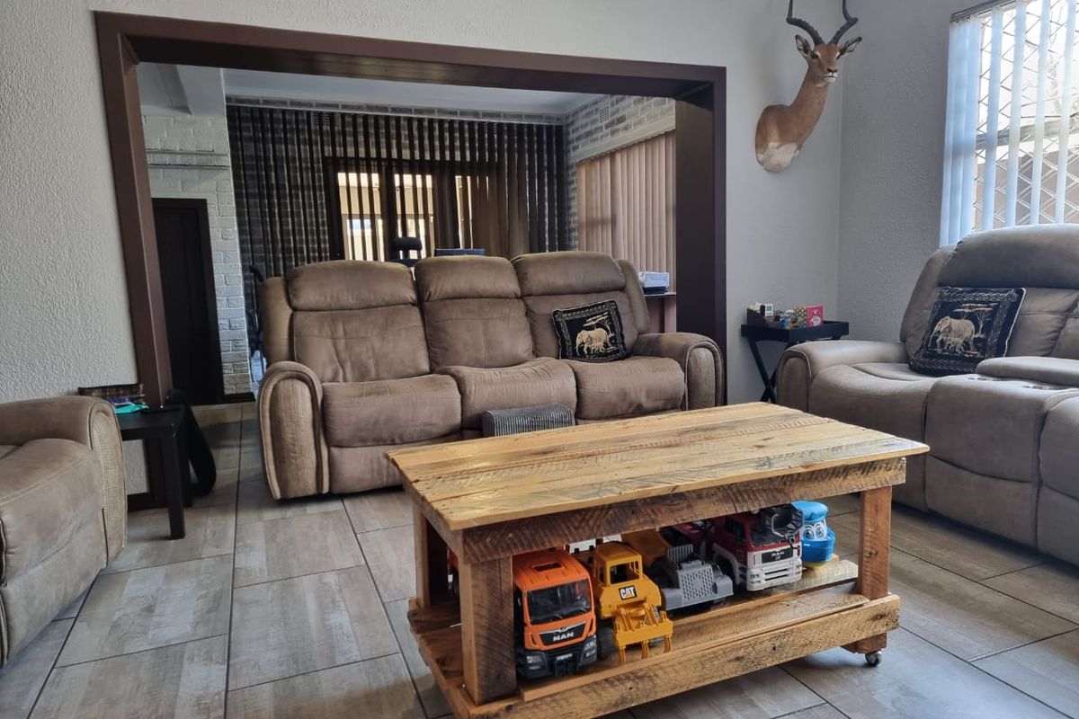 Spacious living room featuring tiled flooring and a large arched opening leading to an adjacent area, providing a versatile layout.