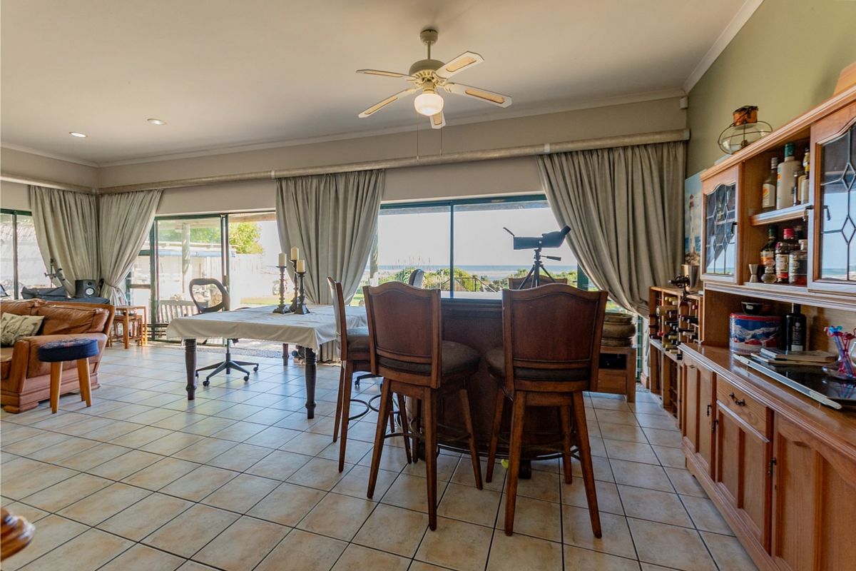 Spacious living area featuring tiled flooring, a ceiling fan, and large sliding glass doors that provide natural light and access to the outdoors.