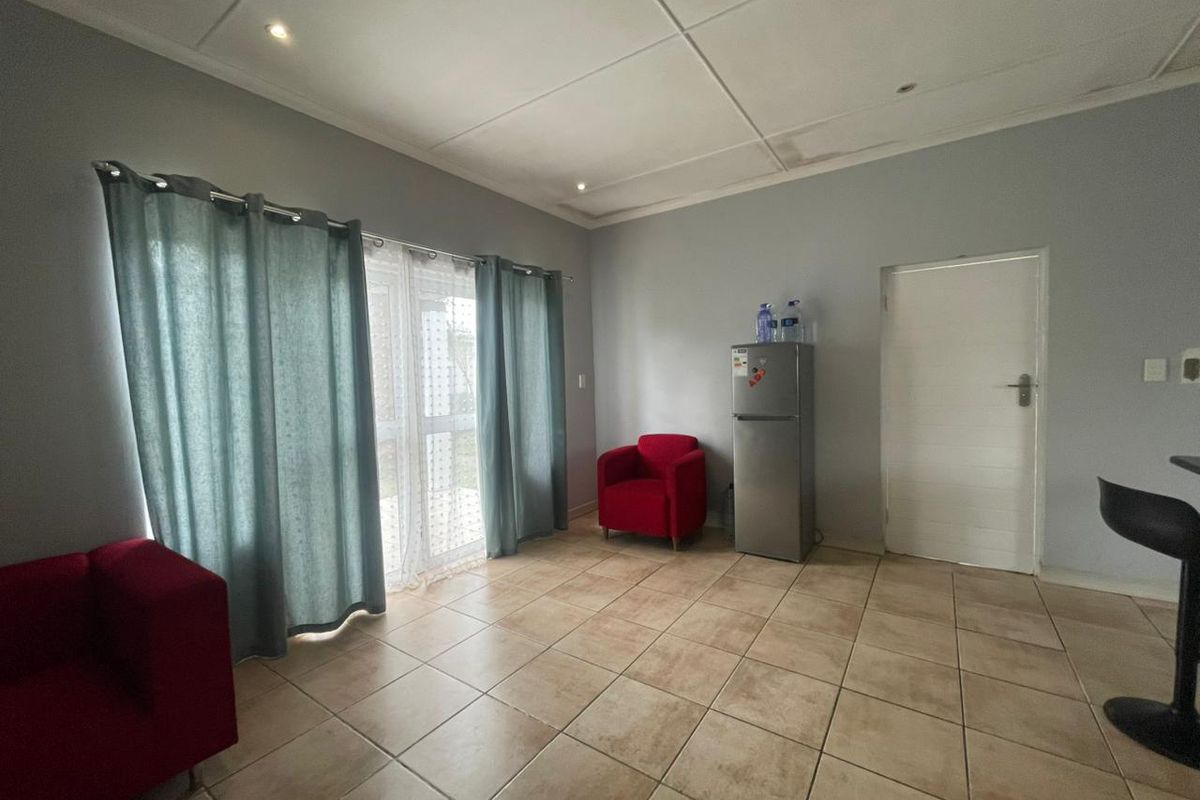 A living area featuring tiled flooring, recessed lighting, and a sliding glass door leading to the exterior, showing signs of ceiling water damage.