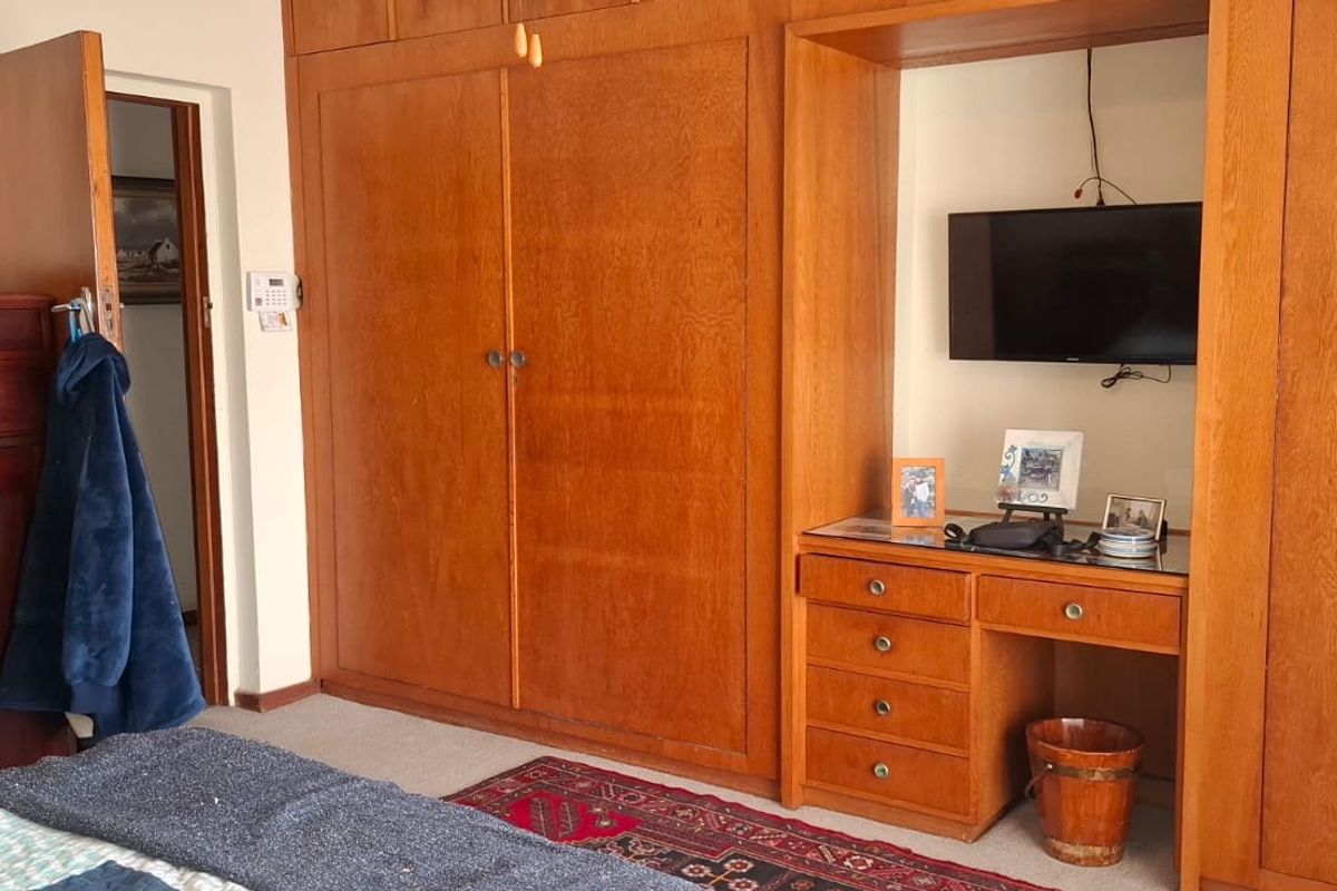 A bedroom featuring extensive built-in wooden cabinetry and an integrated vanity desk, providing ample storage and functional space.