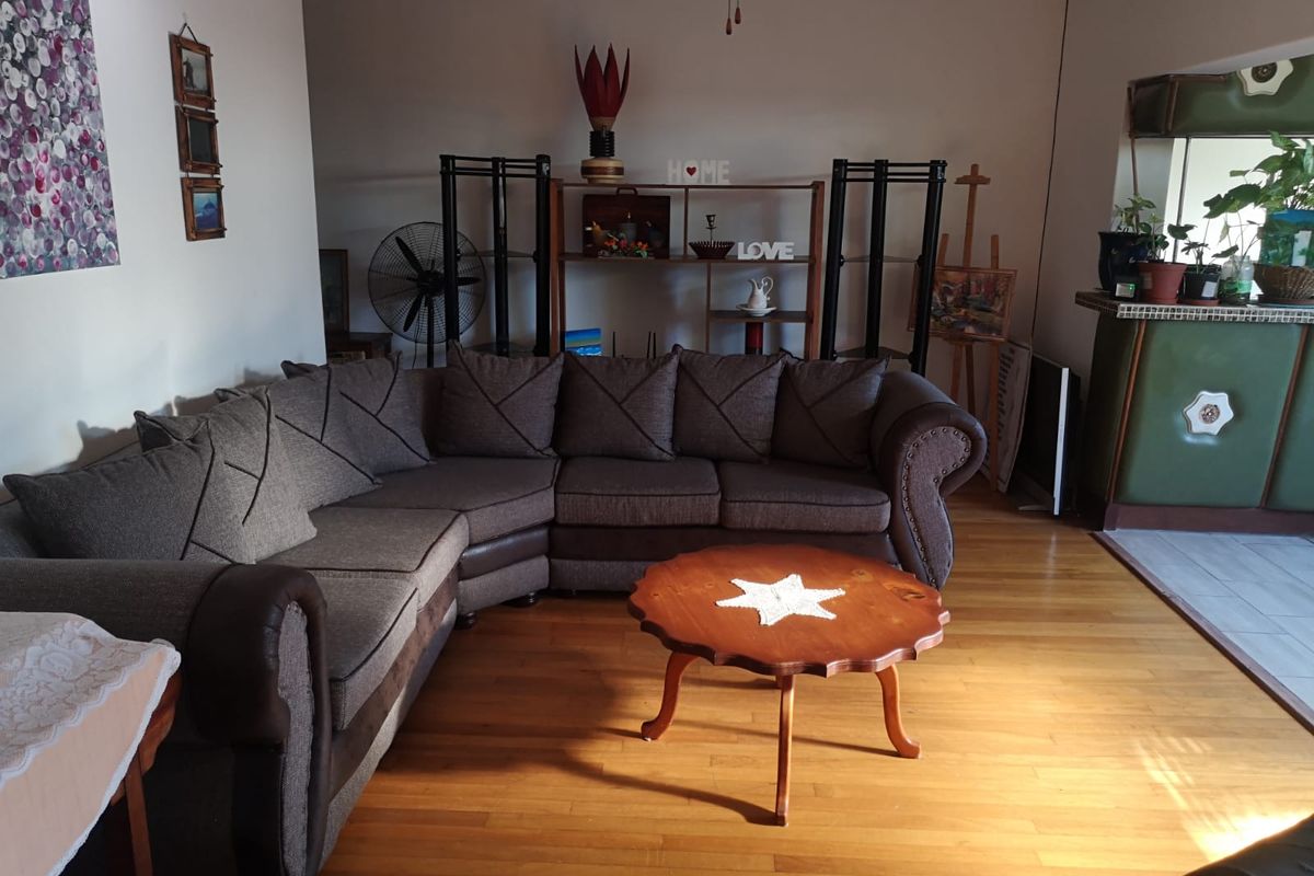 A spacious living room featuring warm hardwood flooring and a built-in bar area, offering a comfortable and functional layout for relaxation and entertaining.