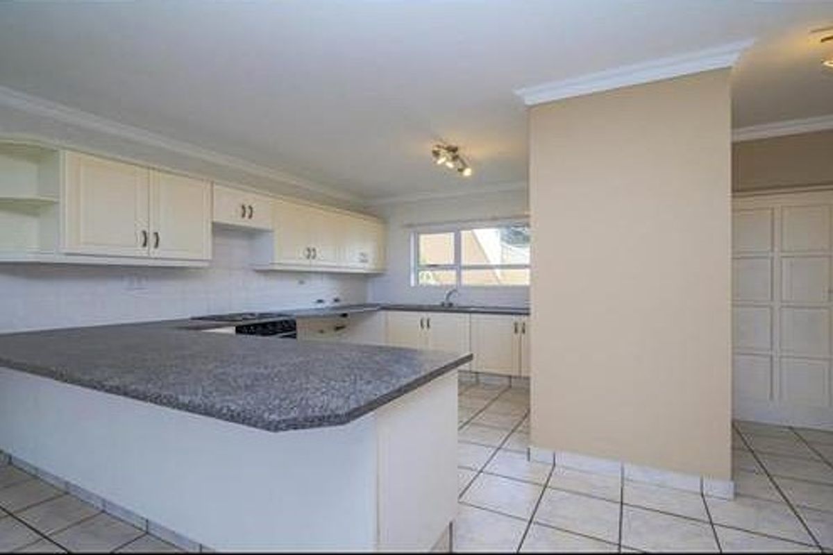 A functional kitchen featuring a breakfast bar, built-in cabinetry, and tiled flooring, offering a practical layout for daily meal preparation.