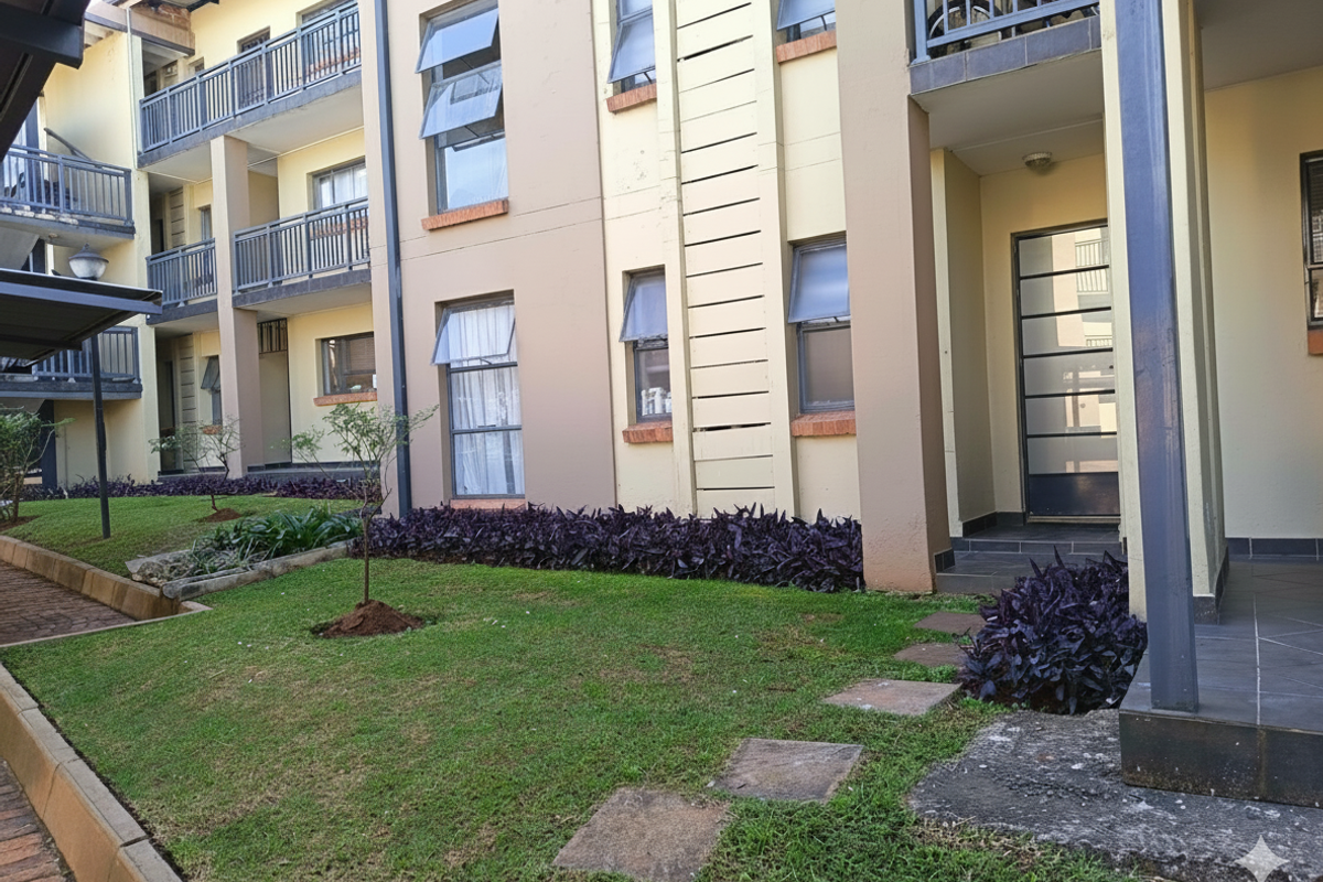 Exterior view of an apartment complex featuring multi-level balconies, metal railings, awning windows, and a landscaped garden area with paved walkways.