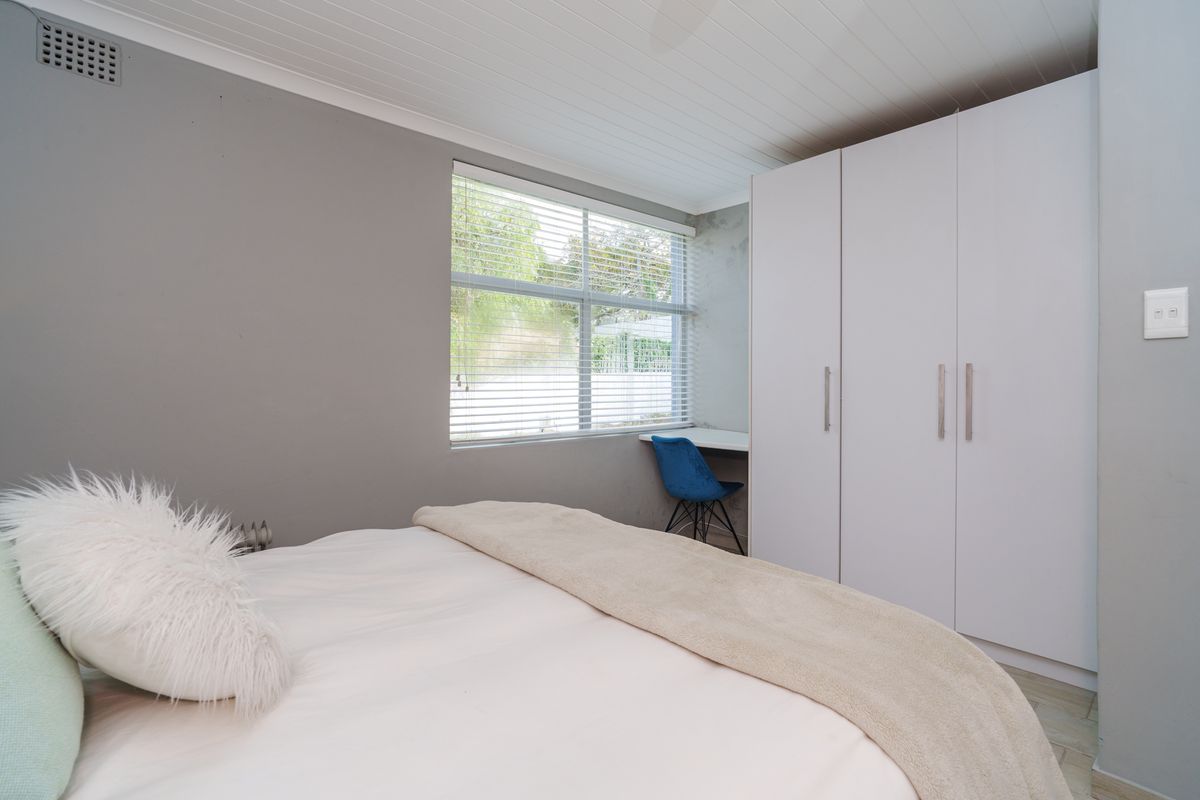Bedroom featuring built-in cupboards, a integrated desk space, and a tongue and groove ceiling with neutral wall finishes.