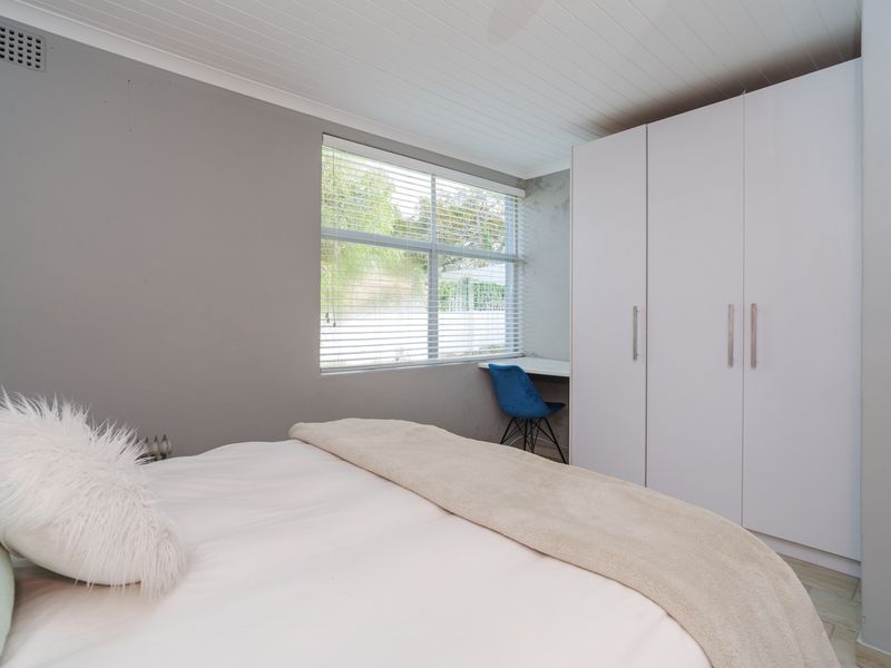 Bedroom featuring built-in cupboards, a integrated desk space, and a tongue and groove ceiling with neutral wall finishes.