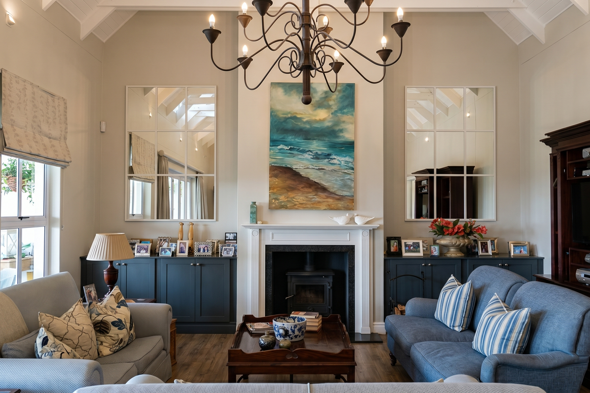 A well-appointed living room featuring a vaulted ceiling, a central fireplace with a wood-burning stove, and custom built-in cabinetry.