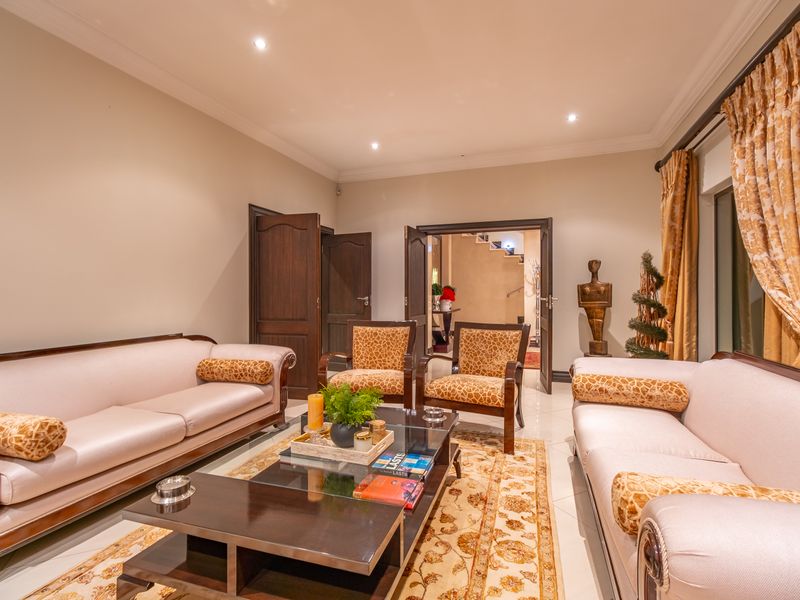 A well-maintained living room featuring tiled flooring, recessed downlighting, and elegant crown molding, providing a comfortable and inviting space.