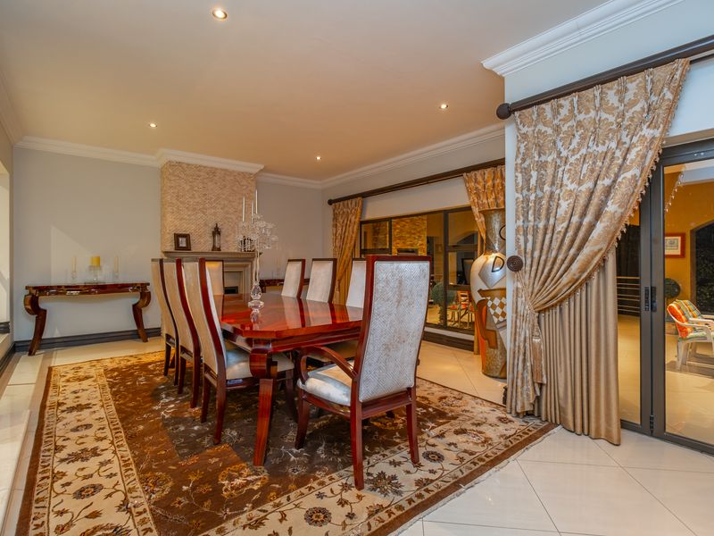 Spacious dining room featuring a fireplace, tiled flooring, and large sliding glass doors that provide access to the outdoor patio area.