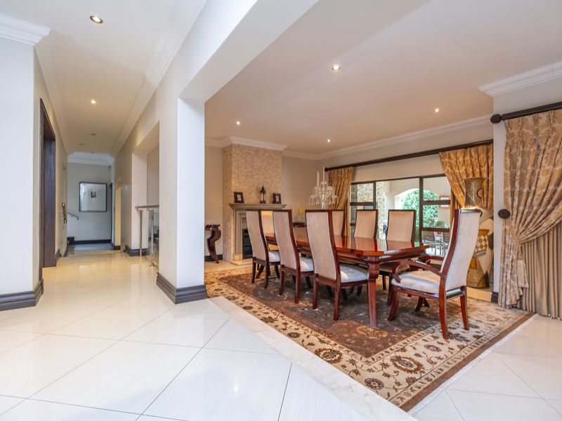 Spacious dining area featuring polished tiled floors, a built-in fireplace, and large sliding glass doors providing access to the outdoor patio.