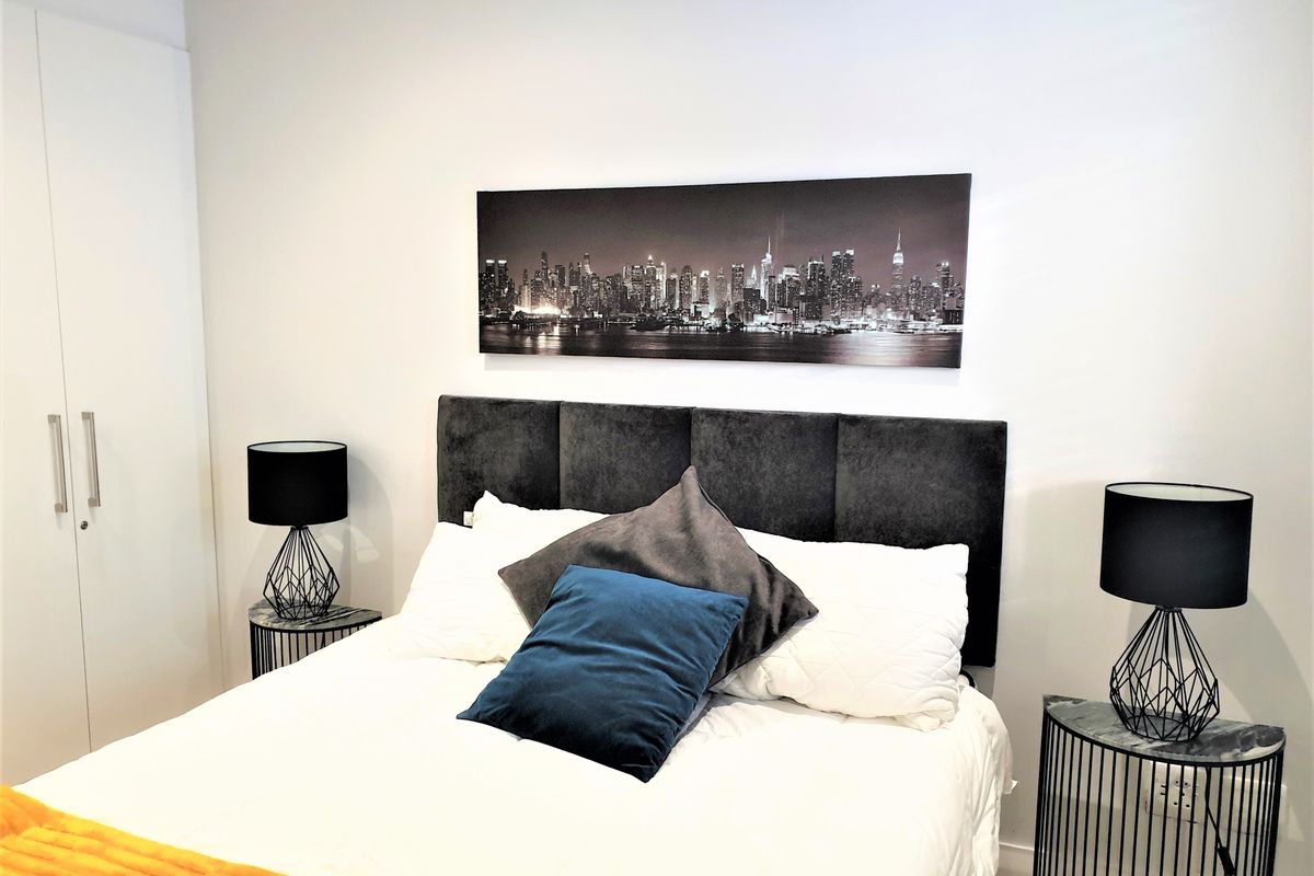 A well-maintained bedroom featuring built-in wardrobes and a neutral color palette, providing a clean and functional living space.