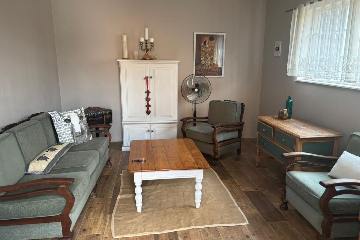 A cozy living room featuring wood-look tile flooring and a window with natural light.