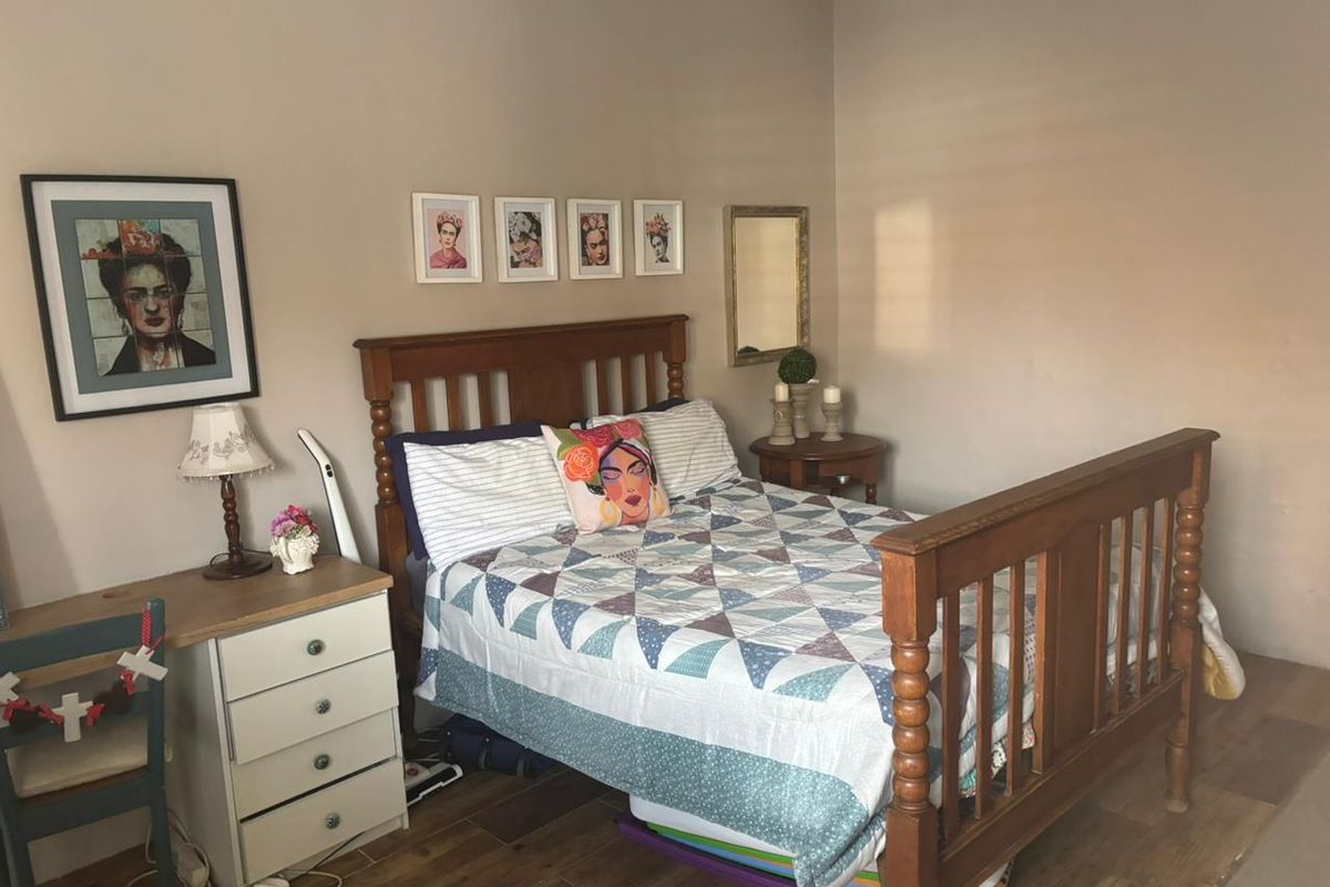 A bedroom featuring laminate flooring and neutral wall tones, providing a functional space for rest.