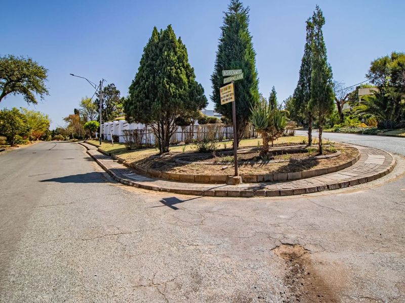 A street view showing the local road infrastructure, including a landscaped traffic island and surrounding residential neighborhood approach.