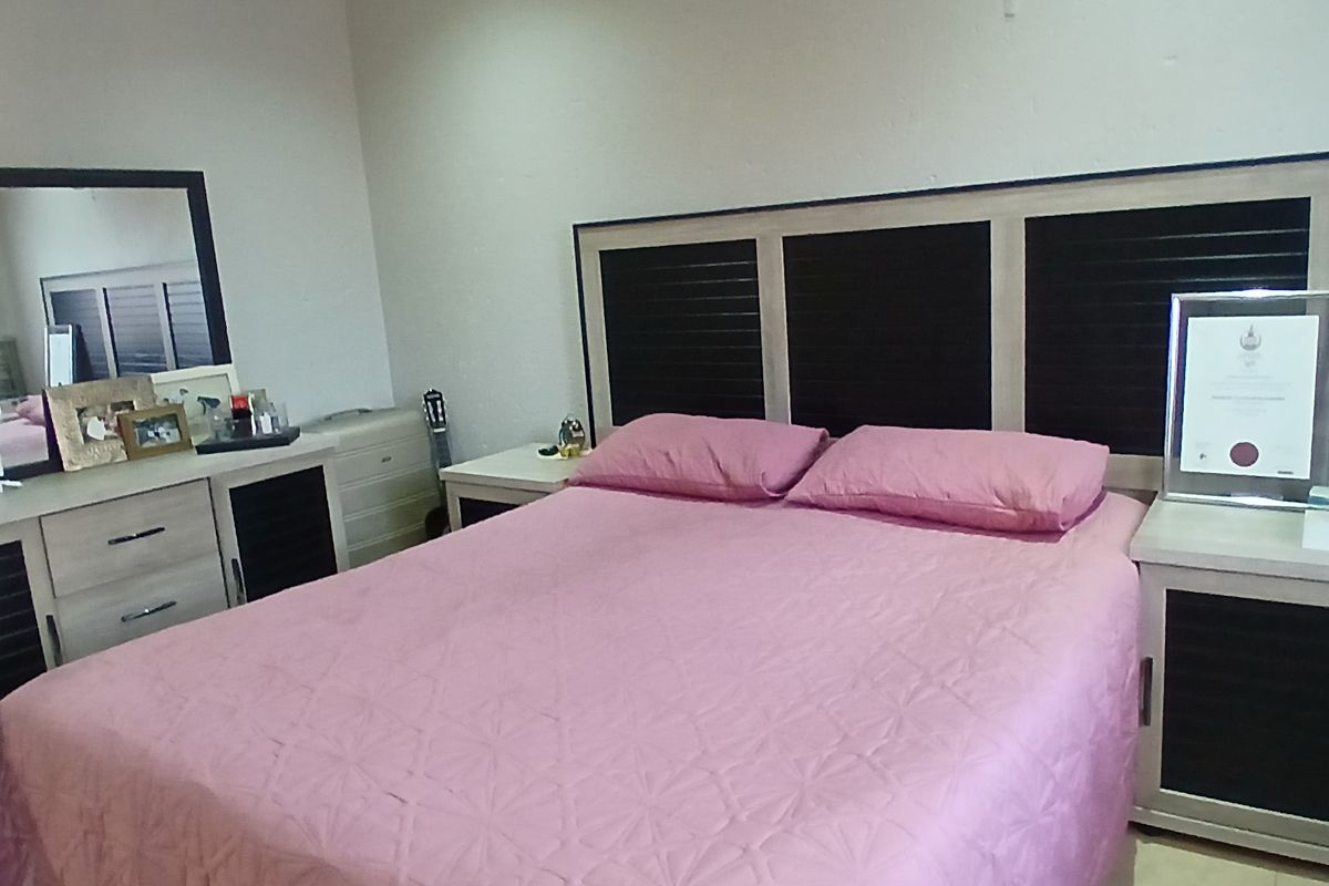 A bedroom featuring a built-in headboard and matching bedside cabinetry with integrated storage.