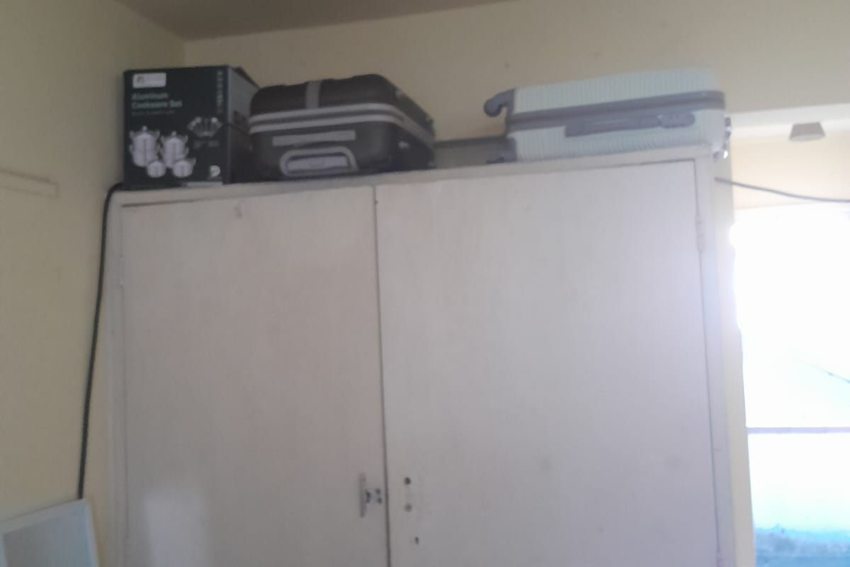 A bedroom featuring a basic built-in cupboard unit.