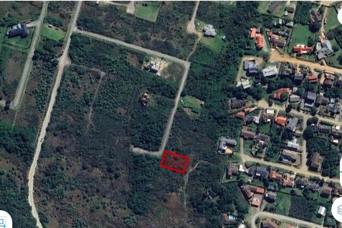 An aerial view of a vacant residential plot situated within a developed neighborhood, highlighting the land parcel and surrounding access roads.
