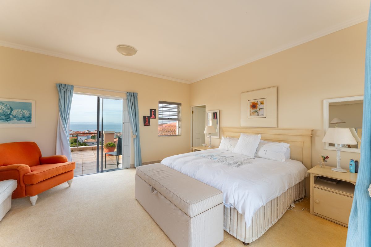 Spacious bedroom featuring neutral carpeting, a built-in headboard, and a sliding glass door providing access to a balcony with scenic views.