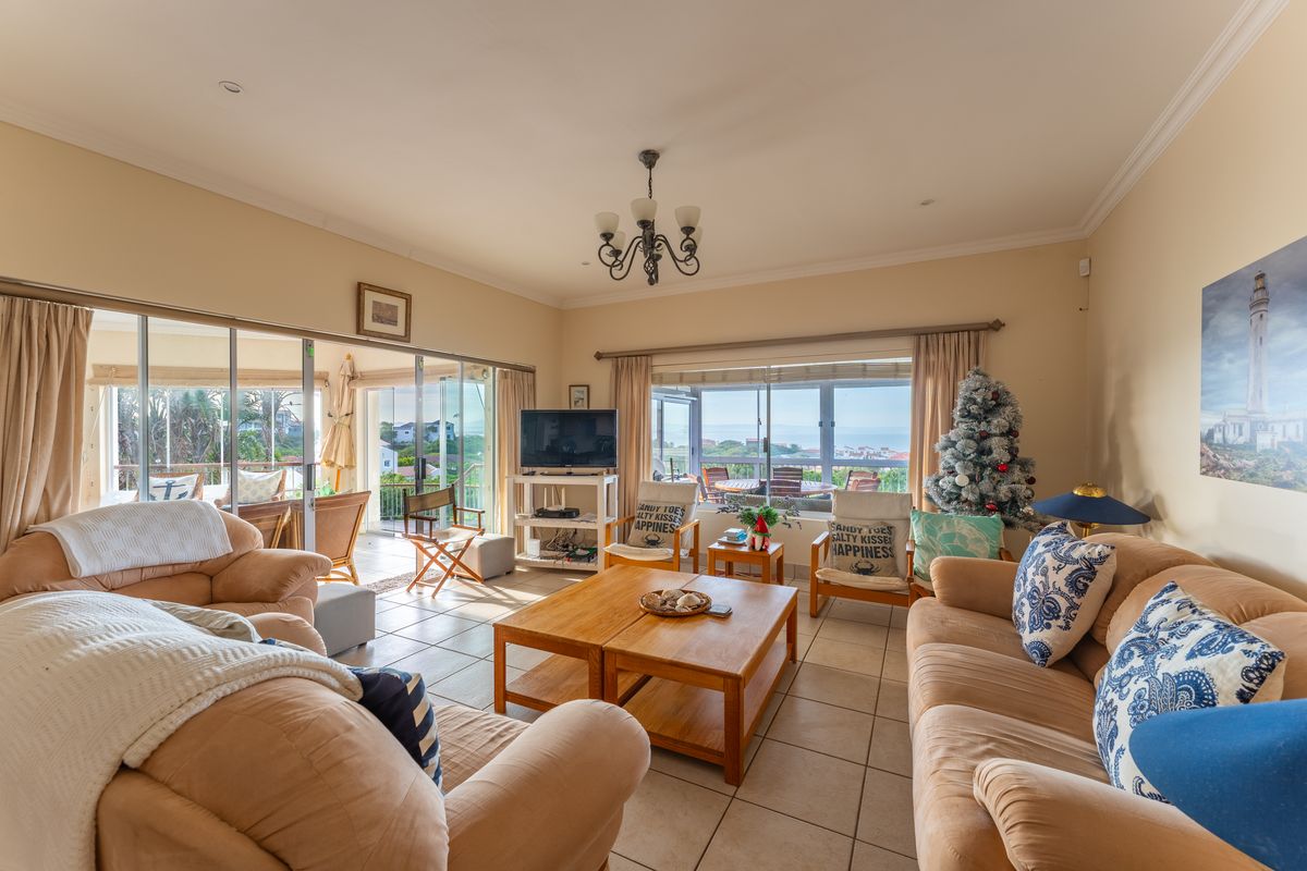 Spacious living room featuring tiled flooring, large sliding glass doors providing natural light, and access to an outdoor patio area.