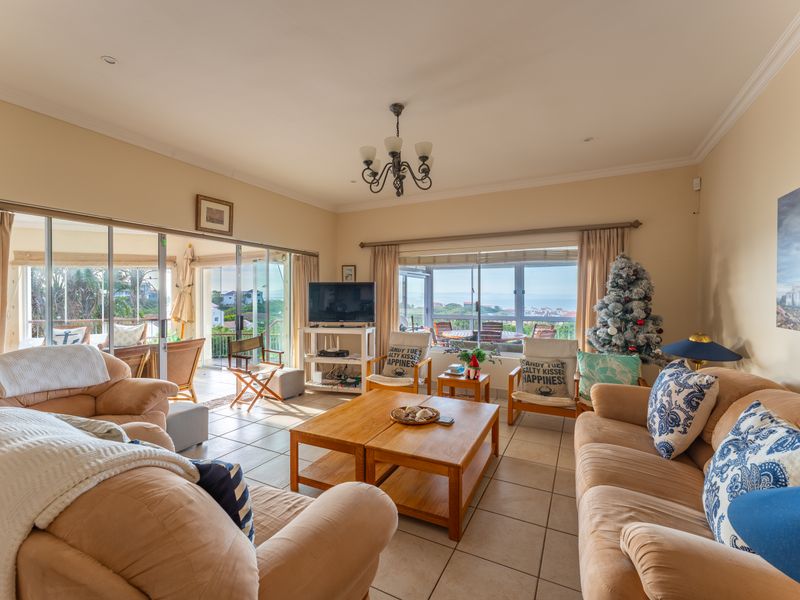 Spacious living room featuring tiled flooring, large sliding glass doors providing natural light, and access to an outdoor patio area.