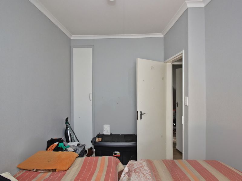 A standard bedroom featuring a built-in cupboard and neutral wall finishes, offering a functional space ready for personalization.