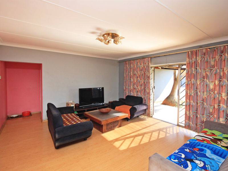 Spacious living room featuring laminate flooring, cove ceiling, and a sliding glass door providing direct access to the outdoor area.